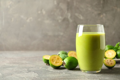 Fresh feijoa smoothie and fresh fruits on grey table, closeup. Space for text