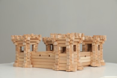Photo of Wooden fortress on white table, space for text. Children's toy