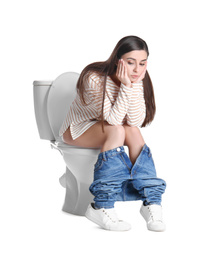 Photo of Upset woman sitting on toilet bowl, white background