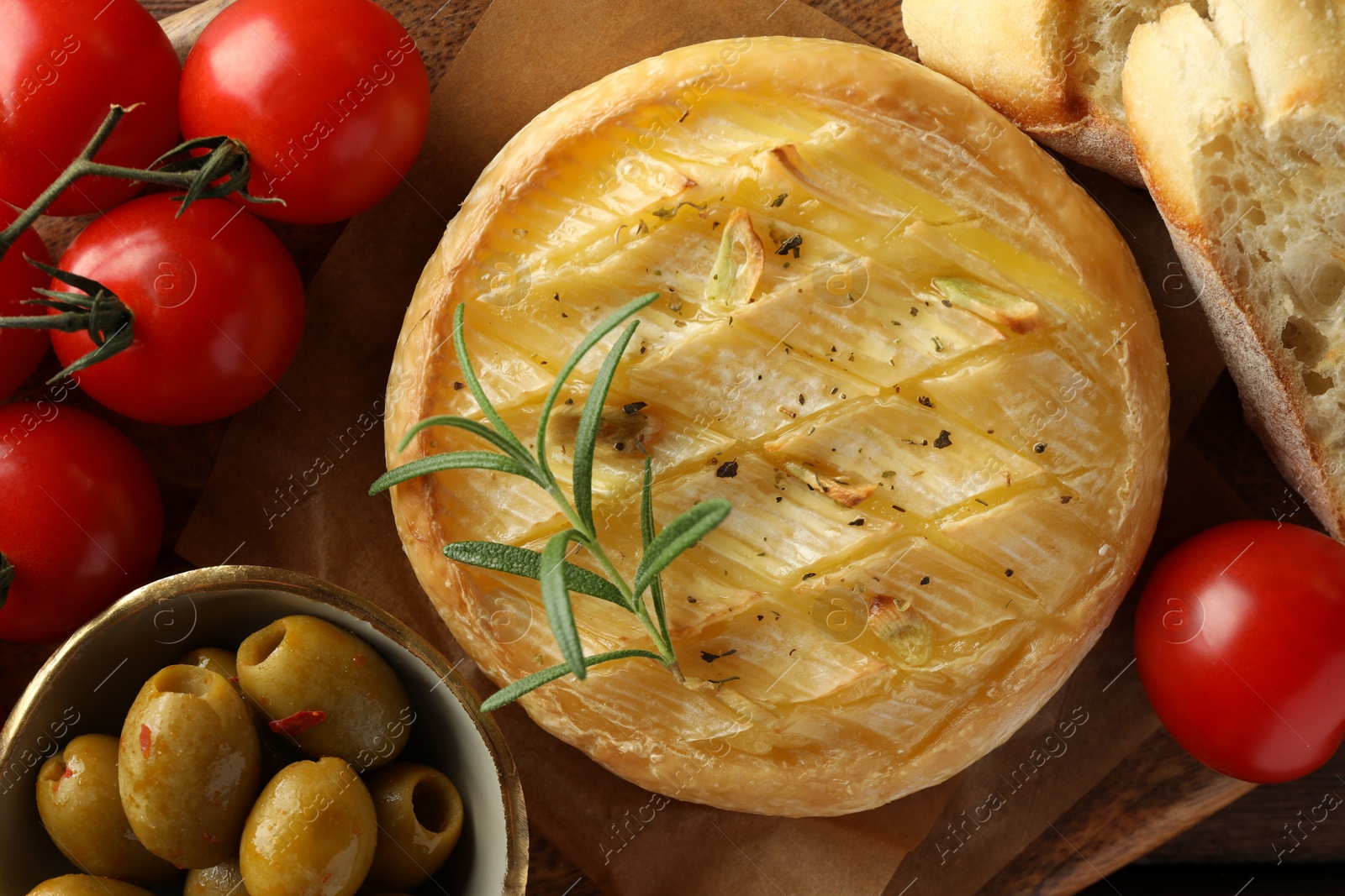 Photo of Tasty baked brie cheese served on board, top view