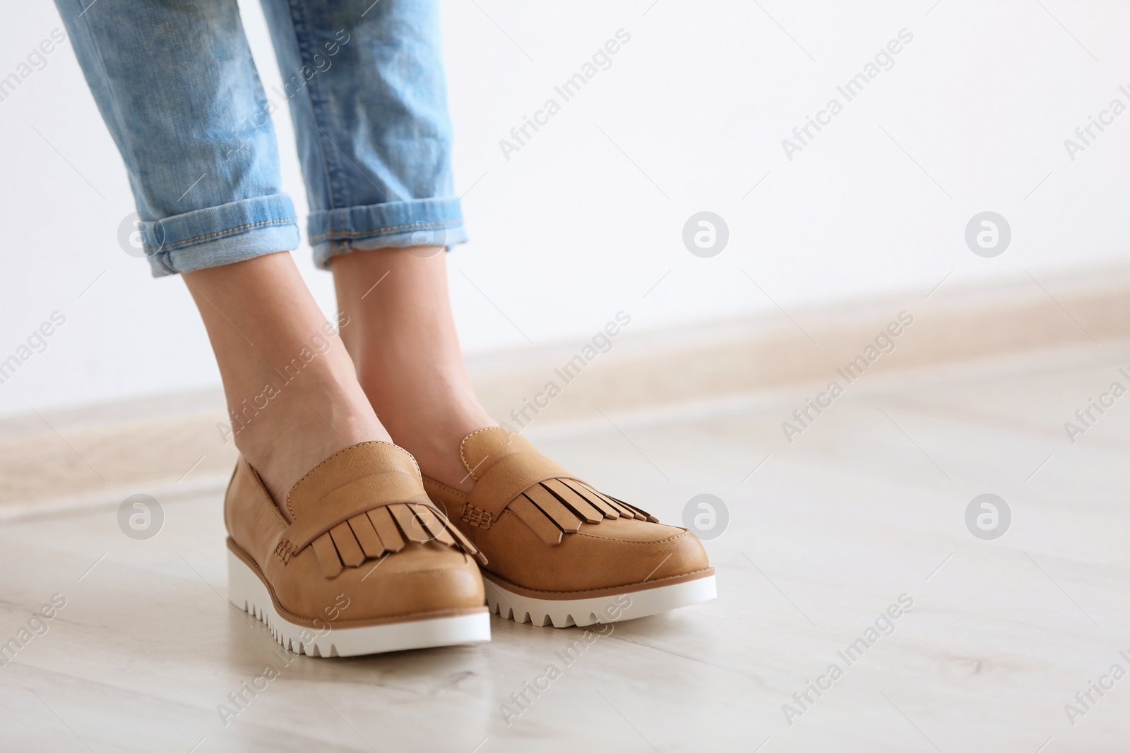 Photo of Young woman wearing elegant shoes indoors, closeup