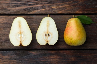 Photo of Whole and half of tasty fresh pears on wooden table, flat lay