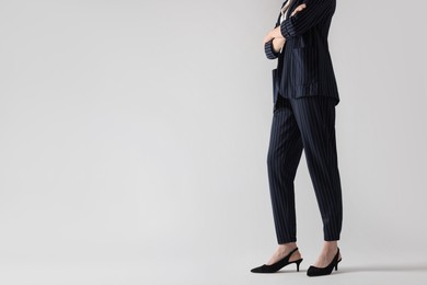 Businesswoman with crossed arms on white background, closeup