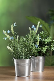 Photo of Different artificial potted herbs on wooden table outdoors