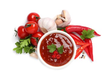 Photo of Spicy chili sauce and ingredients on white background, top view