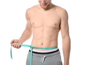 Young man with measuring tape showing his slim body on white background, closeup