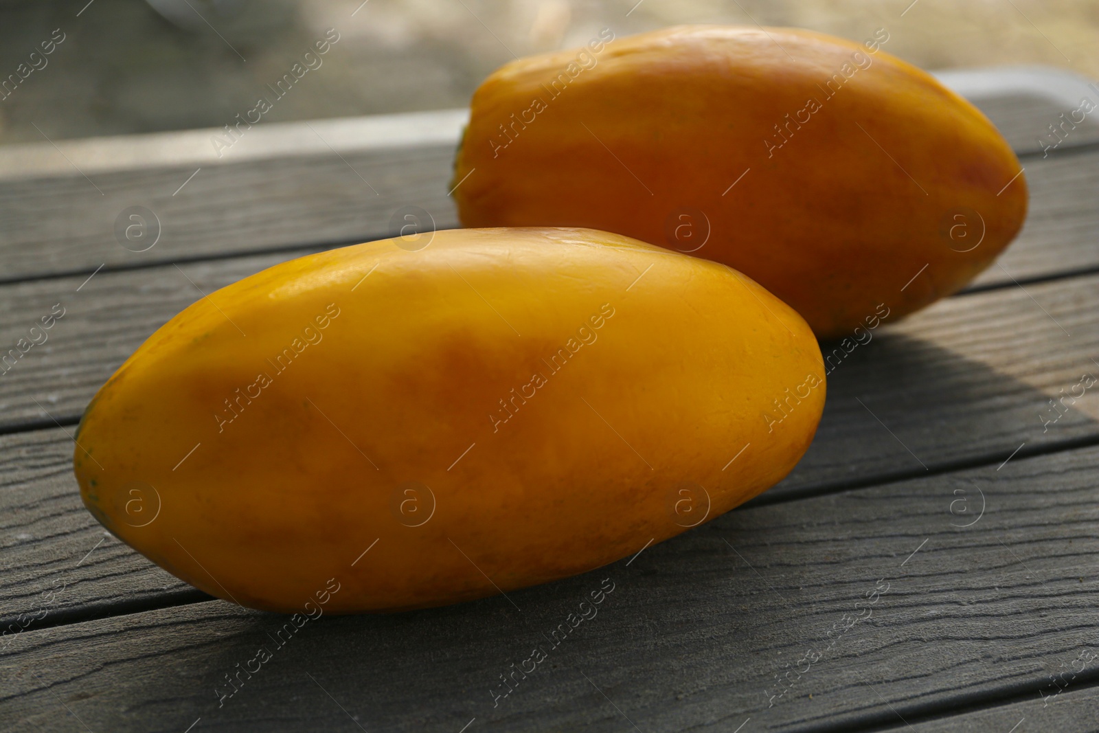 Photo of Fresh ripe papaya fruits on wooden table