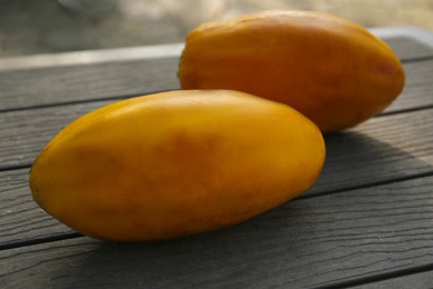 Fresh ripe papaya fruits on wooden table