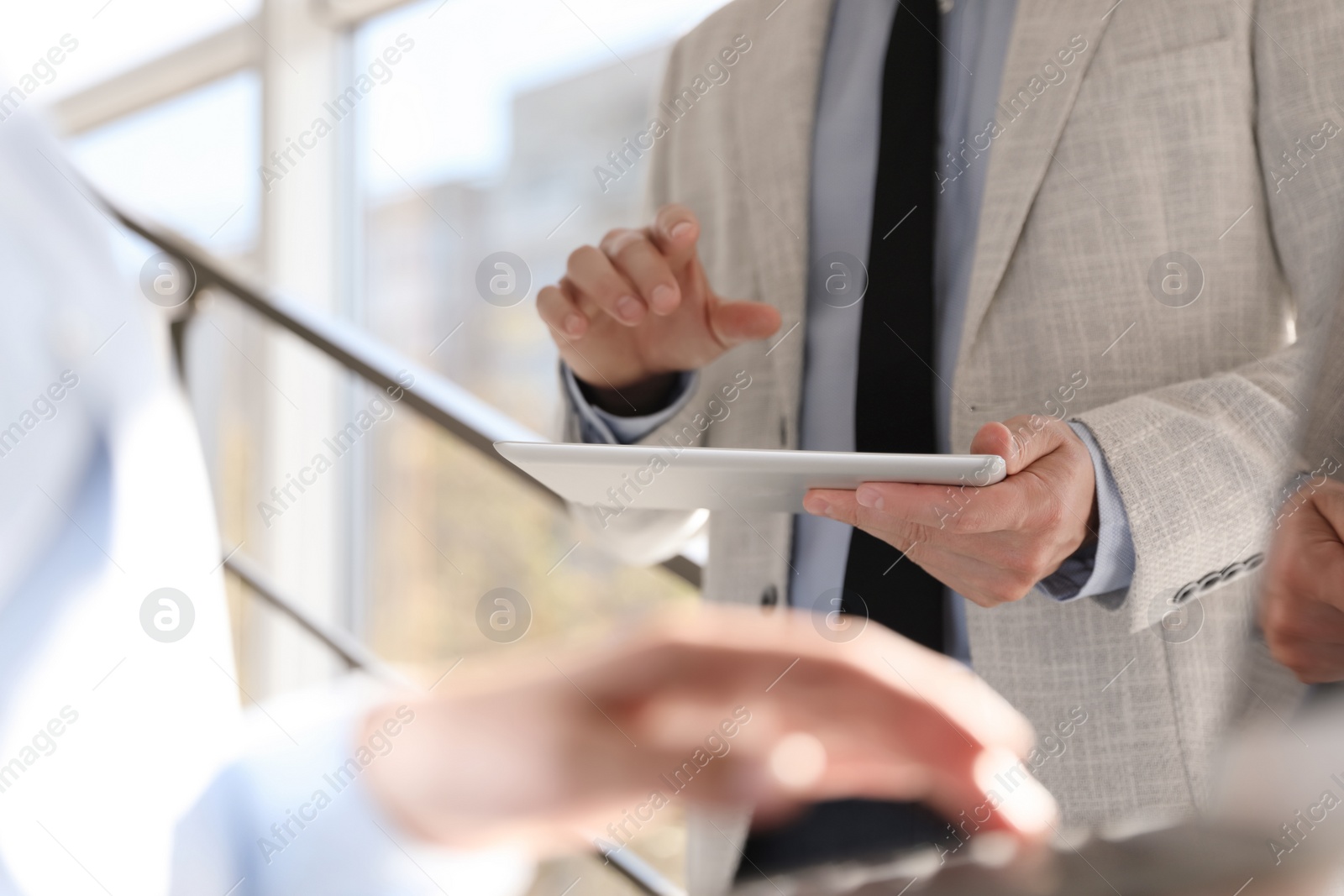 Photo of Businessman working with modern tablet in office, closeup