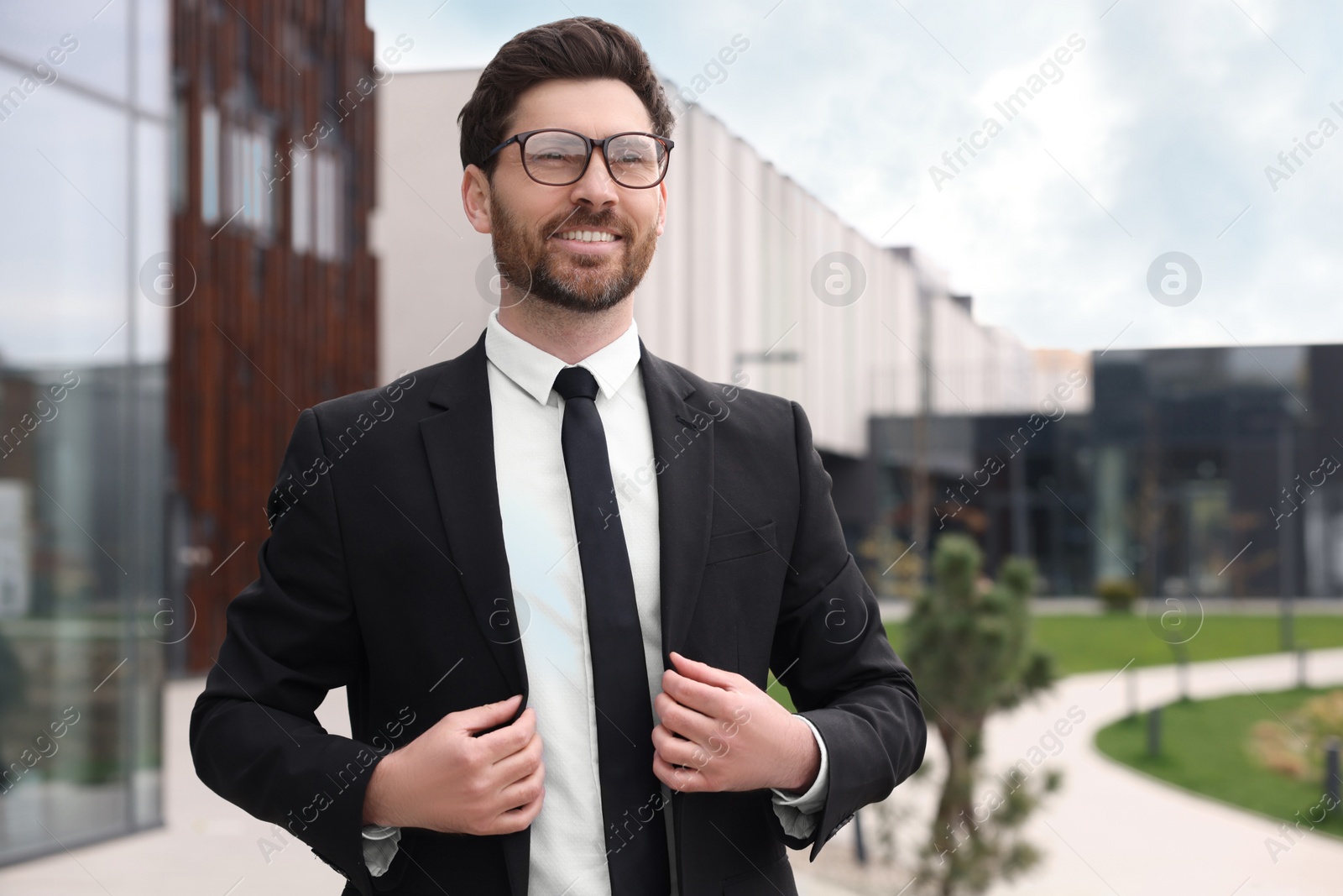 Photo of Handsome real estate agent outdoors. Space for text