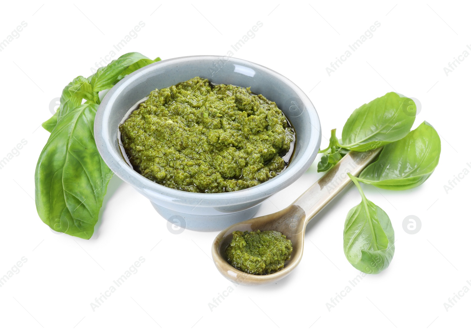 Photo of Fresh tasty pesto sauce and basil isolated on white