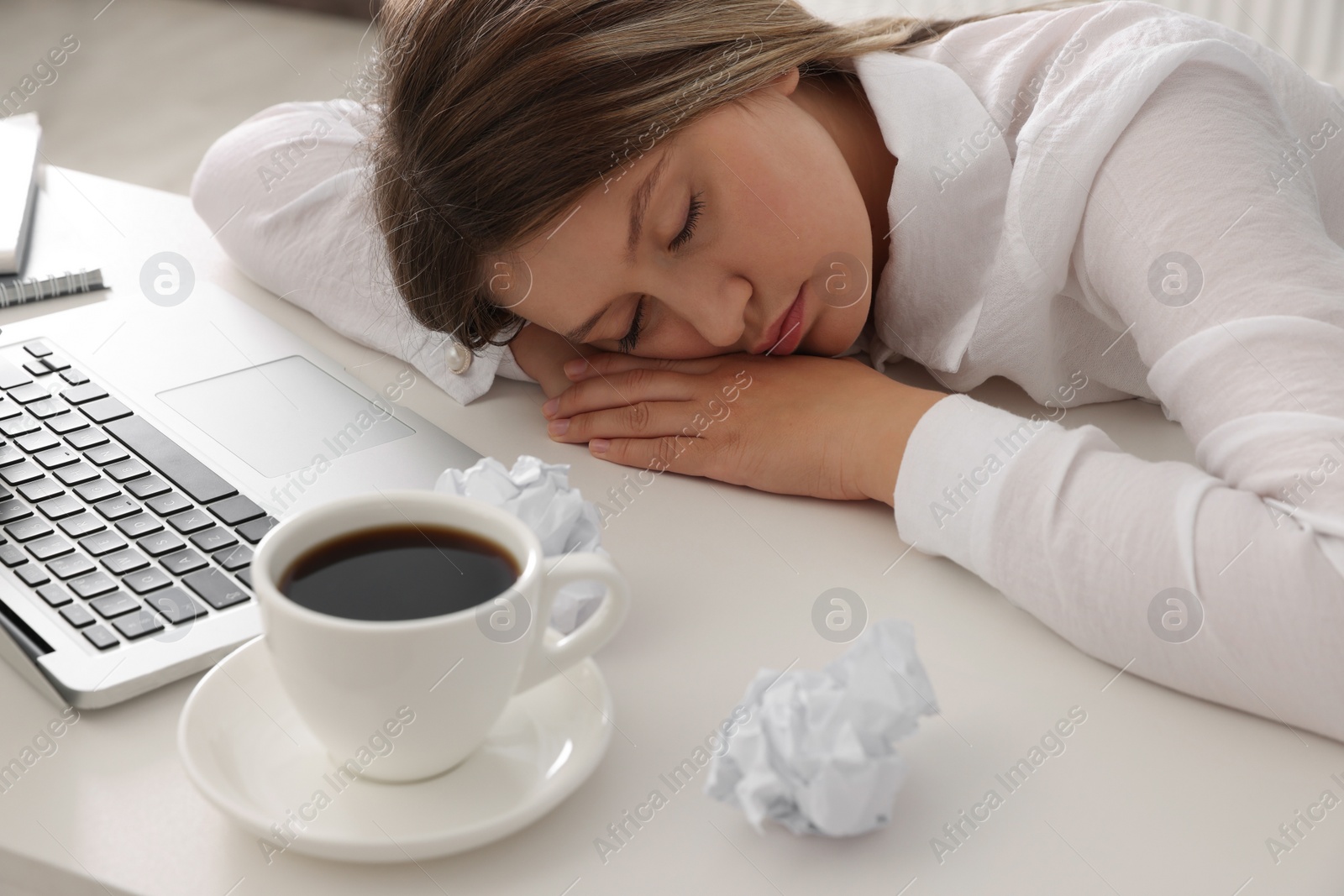 Photo of Tired young woman sleeping at workplace in office