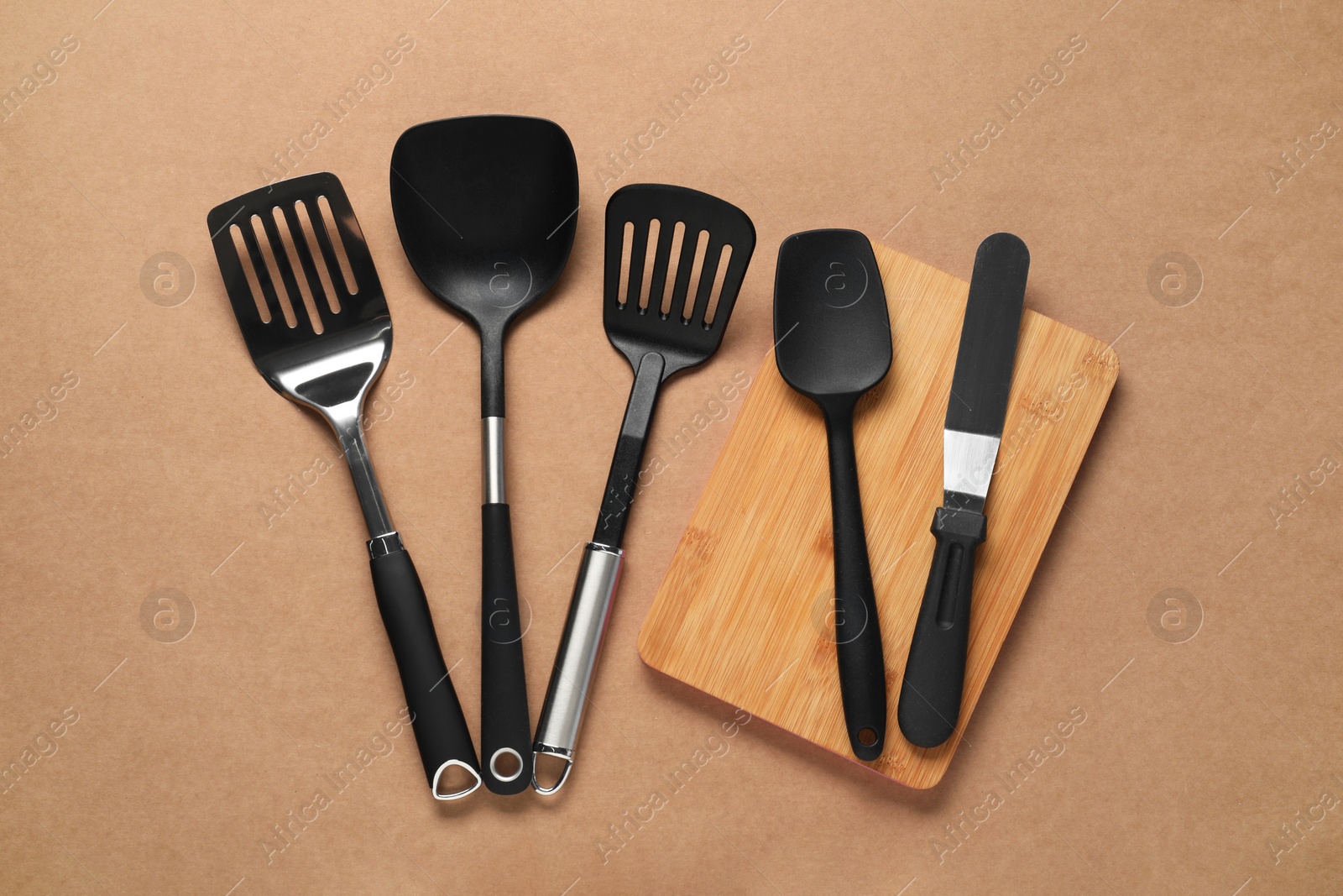 Photo of Different spatulas on brown background, flat lay