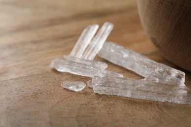 Photo of Menthol crystals on wooden background, closeup view