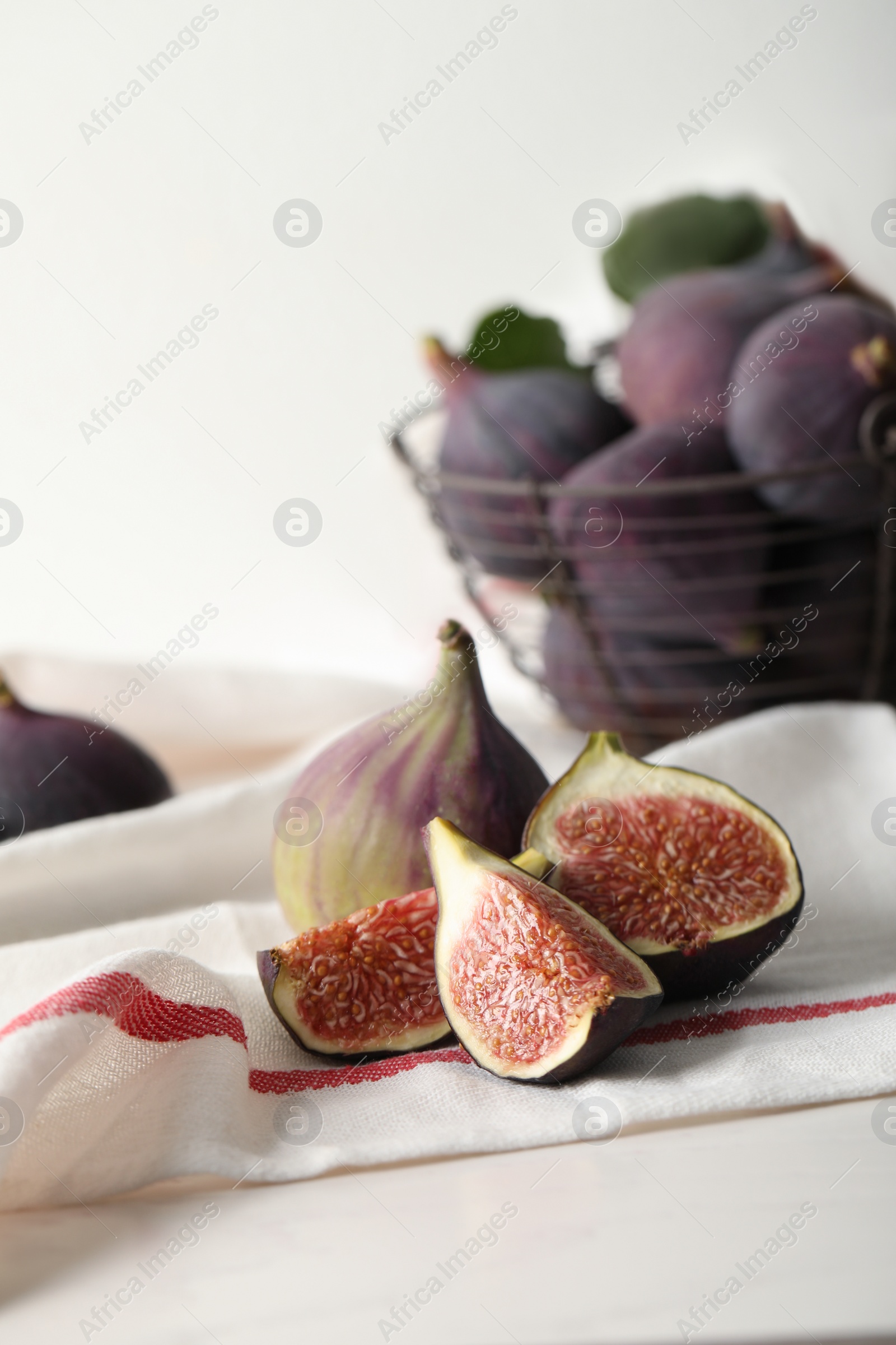 Photo of Tasty cut and whole figs on table with napkin