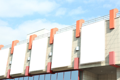 Photo of Blank banners on facade of shopping mall. Advertising board design