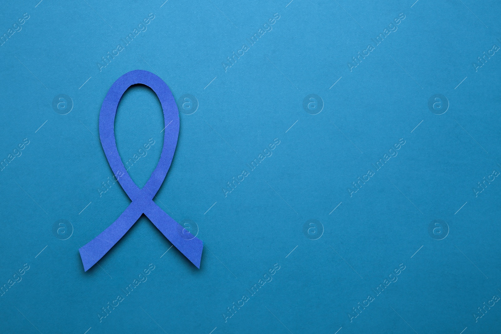 Photo of Blue awareness ribbon on color background, top view with space for text. Symbol of social and medical issues