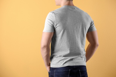 Photo of Young man in grey t-shirt on color background. Mockup for design