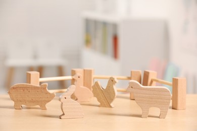 Photo of Wooden animals and fence on table indoors. Children's toys