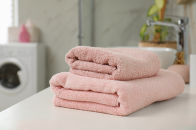 Photo of Stack of clean towels on bathroom countertop