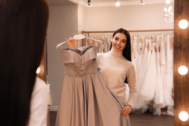 Woman choosing dress in rental clothing salon