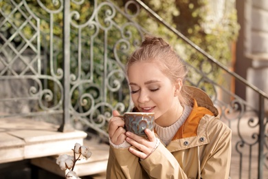 Photo of Portrait of young woman enjoying tasty coffee outdoors