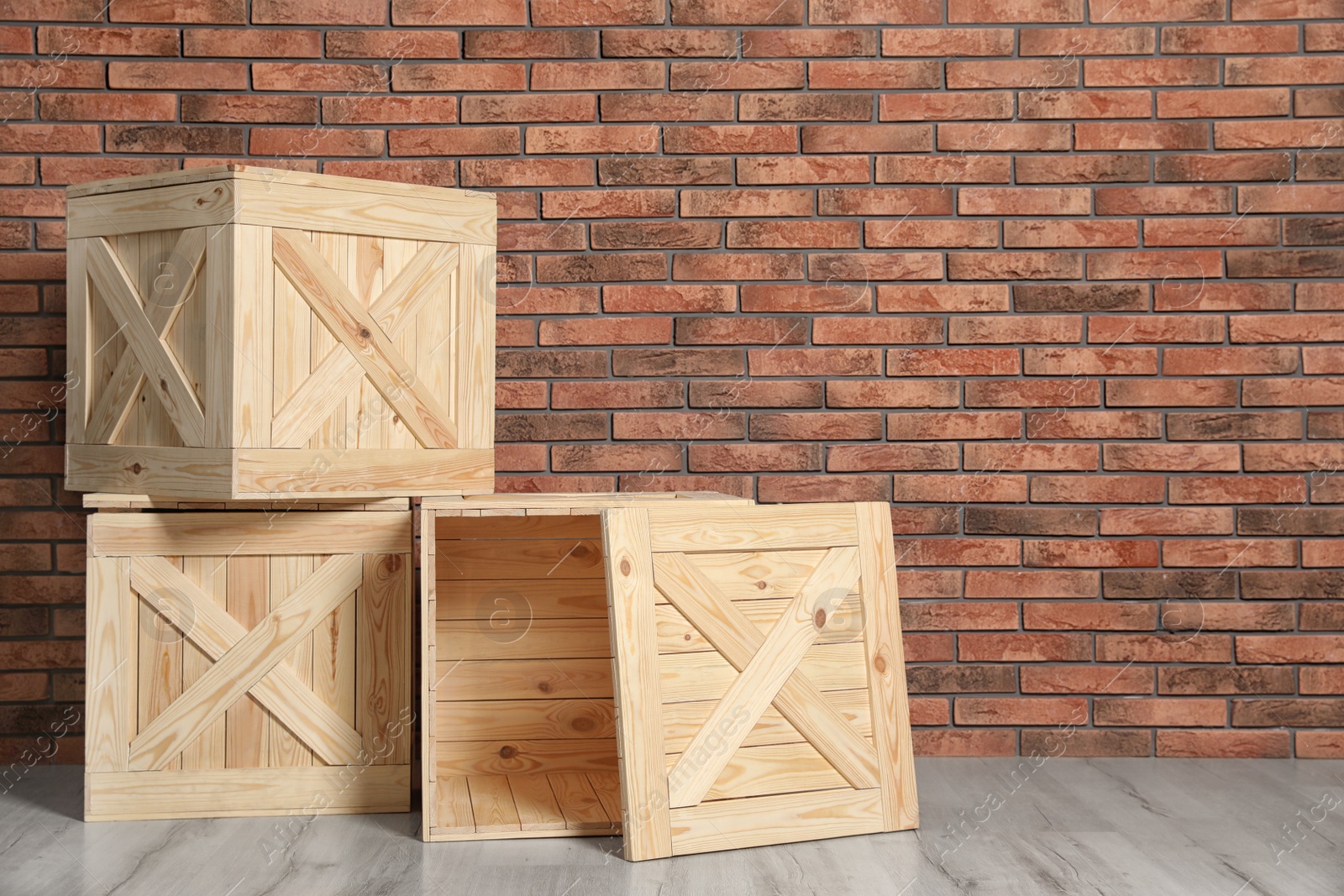 Photo of Wooden crates on floor at brick wall. Space for text