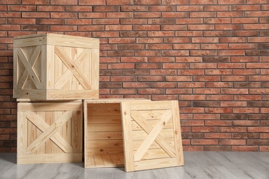 Photo of Wooden crates on floor at brick wall. Space for text