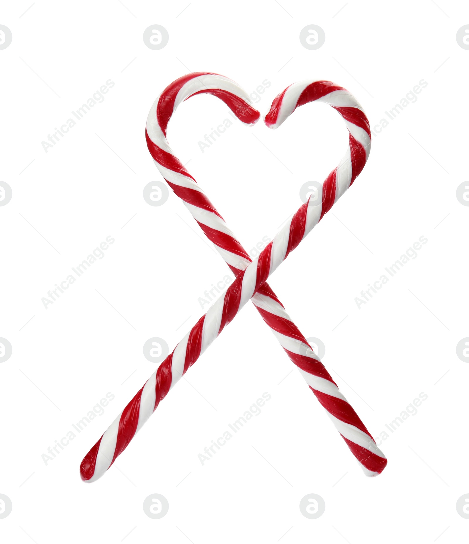 Photo of Heart shape made of tasty candy canes on white background. Festive treat