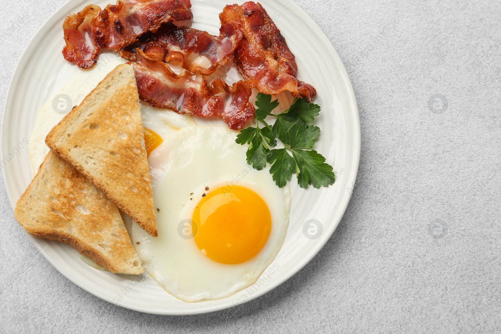 Photo of Delicious breakfast with sunny side up egg on light table, top view