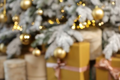 Blurred view of Christmas tree with baubles, lights and gift boxes