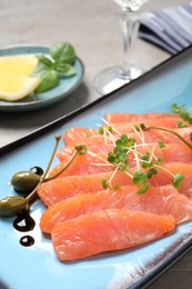 Photo of Delicious salmon carpaccio served on table, closeup