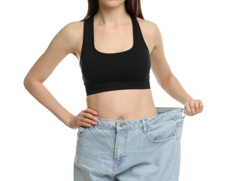 Photo of Woman in big jeans showing her slim body on white background, closeup