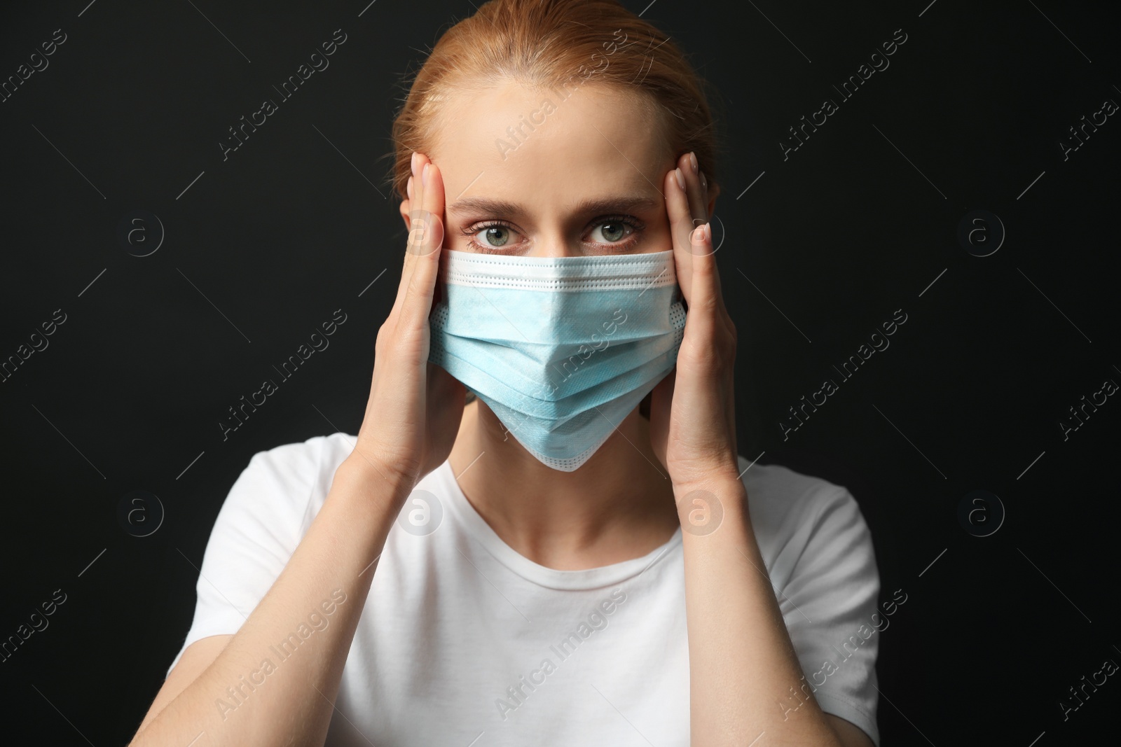 Photo of Young woman with protective mask on black background