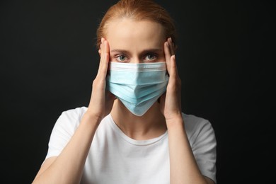 Photo of Young woman with protective mask on black background