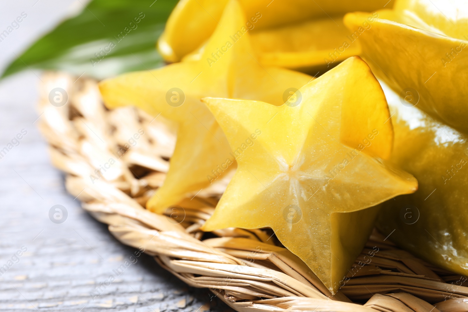 Photo of Delicious carambola fruits on light grey wooden table, closeup