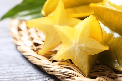 Delicious carambola fruits on light grey wooden table, closeup