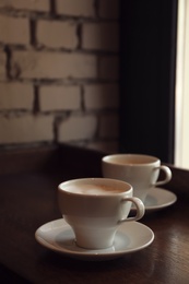 Cups of fresh aromatic coffee on table