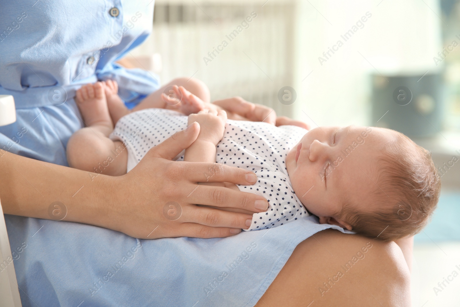 Photo of Young woman with her newborn baby at home, closeup