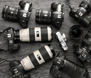 Photo of Modern cameras on dark gray marble table, flat lay