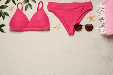 Photo of Stylish bikini and beach accessories on sand, flat lay. Space for text