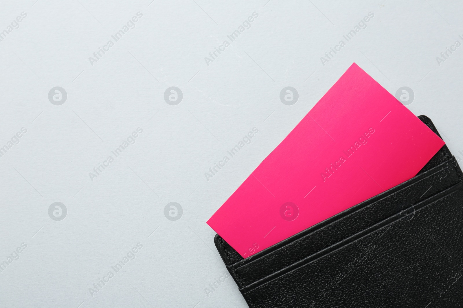 Photo of Leather business card holder with colorful cards on light grey background, top view. Space for text