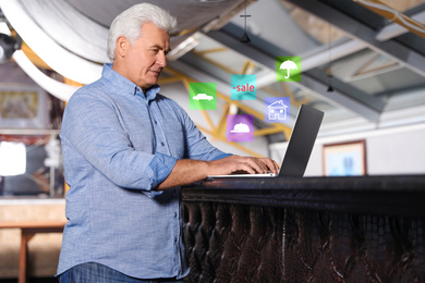 Senior man using laptop in restaurant. Online shopping