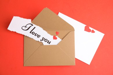 Sheet of paper with phrase I Love You and envelopes on red background, flat lay