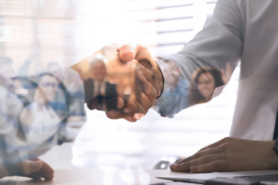 Image of Double exposure of team workers and business partners shaking hands in office, closeup 