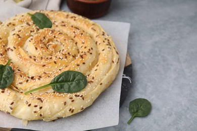 Photo of Delicious puff pastry with spinach on grey table, closeup