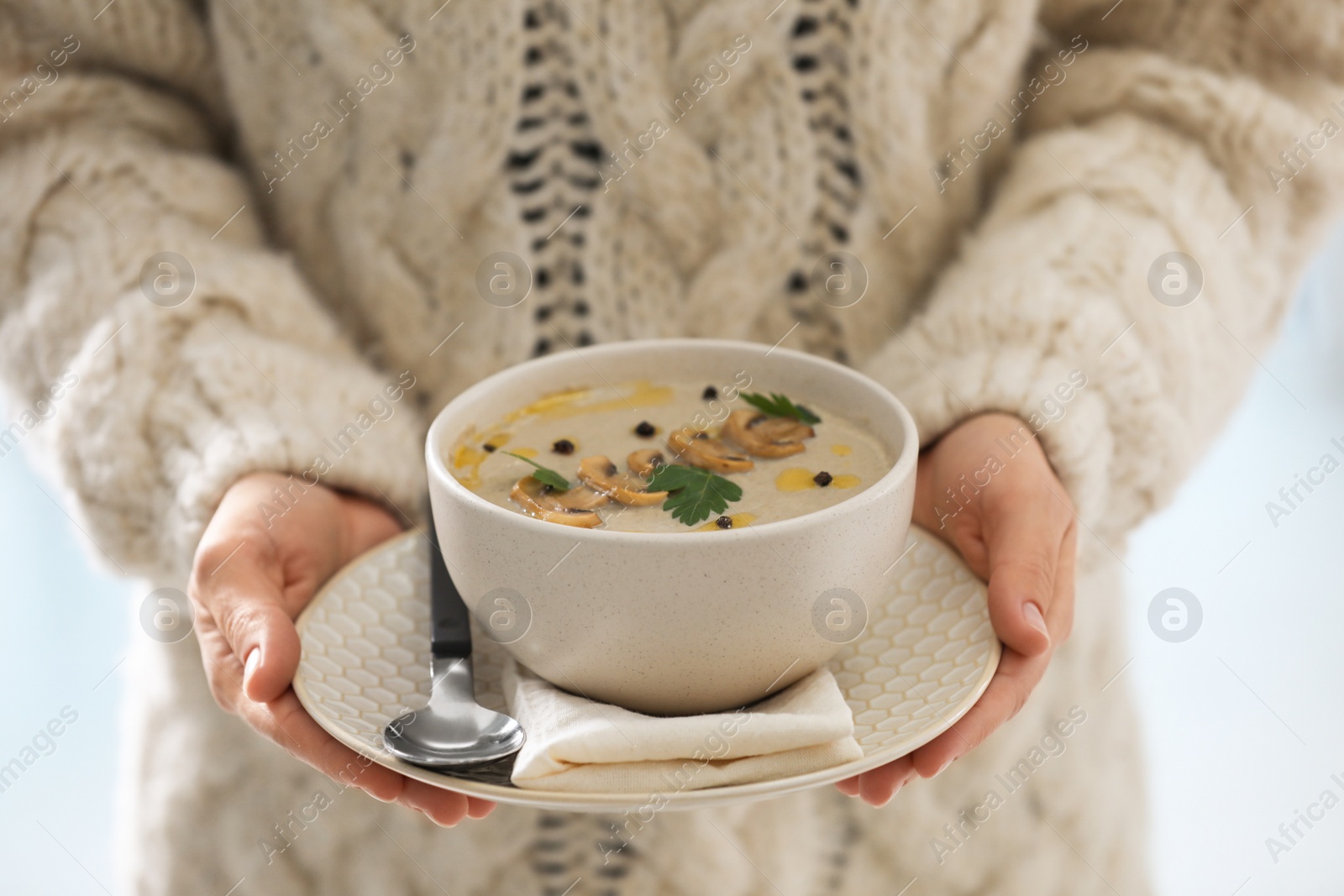 Photo of Young woman with bowl of cream soup, closeup