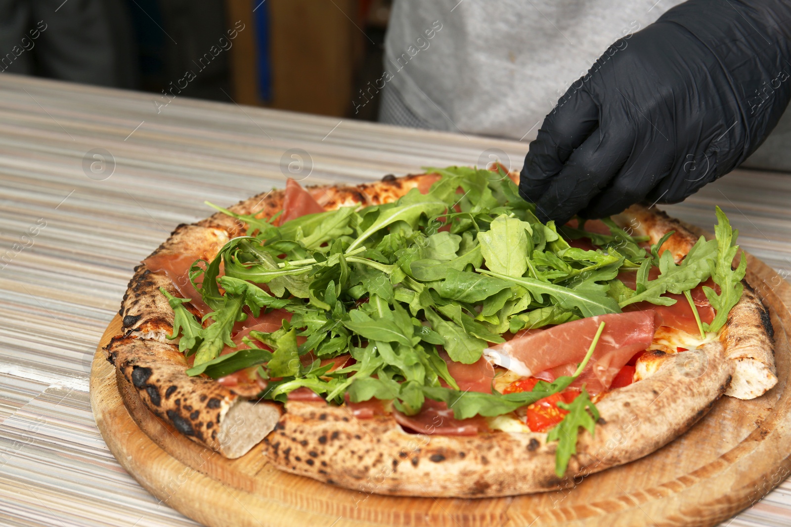 Photo of Professional chef preparing Italian oven baked pizza in restaurant, closeup