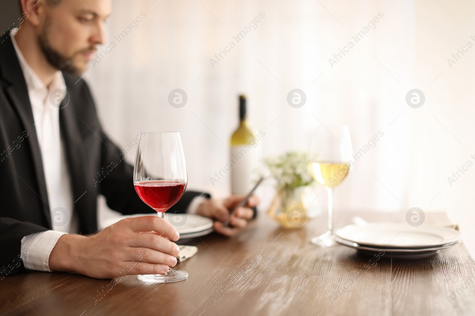 Photo of Man with glass of wine at table in restaurant