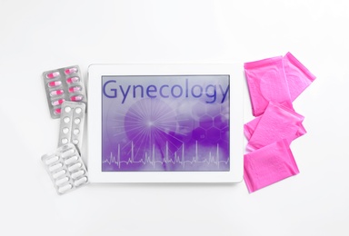 Flat lay composition with tablet, menstrual pads and pills on white background. Gynecology concept